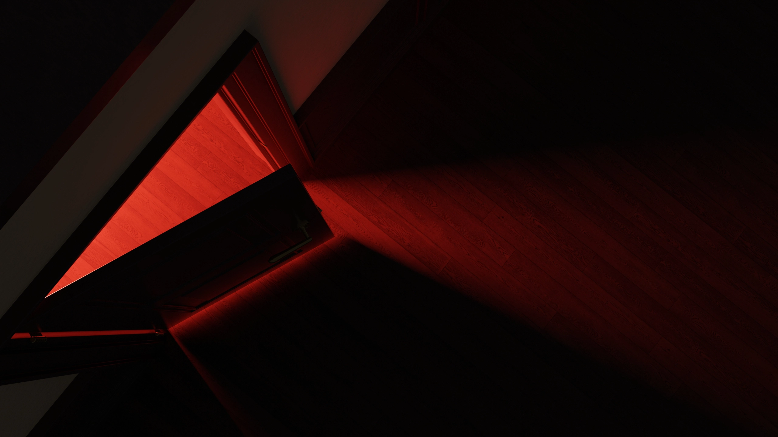 Overhead view of an open door casting red light across wooden floorboards